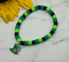 a green and black beaded bracelet with a st patrick's day hat charm