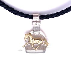 Ashley's signature 14k yellow gold Extended Trot horse in Sterling Silver Stirrup Necklace is hand made and hand finished in the USA for superior quality by Ashley's. Stirrup size is 3/4"W x 1 3/8"L. Chain sold separately. Formal Sterling Silver Jewelry With Horse Design, Elegant Yellow Gold Jewelry With Horse Design, Classic Horse Design Pendant Necklace, Elegant Horseshoe Jewelry With Horse Design, Elegant Horseshoe-shaped Horse Design Jewelry, Classic Formal Jewelry With Horse Design, Formal Silver Jewelry With Horse Design, Elegant Gold Jewelry With Horse Design, Formal Horse Design Pendant Jewelry