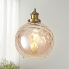 a light that is hanging from a ceiling in a room with white walls and windows