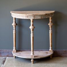 a wooden table sitting on top of a floor next to a gray wall in a room