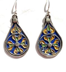 this is a beautiful pair of vintage style silver Berber enamelled earring from Morocco.  It is all handmade by the best Berber silver smith in Morocco.  The silver is over 90% Size: 2 inch long and 22mm wide Pierced Dangle Earrings In Enamel, Artistic Enamel Drop Earrings, Green Enamel Earrings With Artistic Design, Enamel Teardrop Jewelry With Matching Earrings, Artistic Design Enamel Drop Earrings, Multicolor Enamel Jewelry, Silver Teardrop Earrings With Artistic Design, Teardrop Enamel Earrings For Gifts, Teardrop Meenakari Jewelry Gift