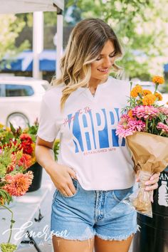 Looking for a trendy sorority tee that's different? 🫶🏻 This Kappa Kappa Gamma Happy to be Notch Tee is the answer! Whether you're giving this tee as a gift or treating yourself with something new, you'll be obsessed with this sorority t-shirt! 🌊 YOU'LL LOVE THIS STYLE 🌊 Meet the Kappa Kappa Gamma Happy to be Notch Tee - the ultimate twist on the classic white t-shirt! Our notch tee features a unique v-neck notch at the neckline, perfect for layering your favorite necklaces. The lightweight, Preppy Short Sleeve T-shirt For Spring, Spring Preppy Short Sleeve T-shirt, Sorority Short Sleeve Tops With Letter Print, Sorority Letter Print Short Sleeve Tops, Sorority Style Letter Print Tops For College, Sorority Letter Print Tops For College, Sorority Short Sleeve Tops For Spring, Sorority Style Short Sleeve Tops For Spring, Short Sleeve Sorority Tops For Spring