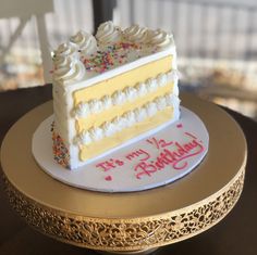 a white and yellow cake with sprinkles on it sitting on top of a table