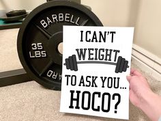 someone holding up a card that says i can't weight to ask you hoco?