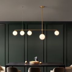 an elegant dining room with dark green walls and gold accents, along with modern chairs