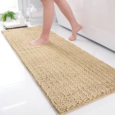 a person walking across a bathroom rug on the floor