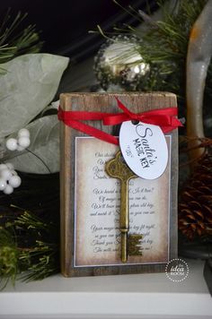 an old key with a red ribbon tied around it is sitting on a shelf next to christmas decorations