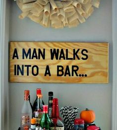 a man walks into a bar sign with liquor bottles on the table and decorations around it