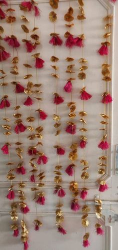 some gold and pink feathers hanging on a wall