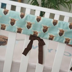 a baby crib with a brown bow on it's head and buffalo print