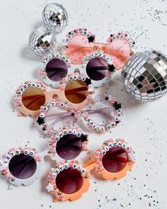 several pairs of sunglasses sitting next to a disco ball