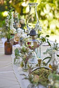 there are many vases and plants on the table