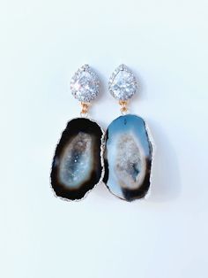 Meet, Gemma. One of our Signature styles. She features a Silver CZ post with a geode that is set in 24kt gold or silver. She can be customized and comes in other colors too. Please note, each geode is beautiful and unique. This is what makes each pair so special. Each stone is similar, but not exact. Please contact us directly to see images of the actual stone. CZ is also available in Rose Gold. Dimensions: 2” Silver Agate Geode With Natural Stones, Unique Silver Gemstone Geodes, Unique Silver Geode With Gemstone Details, Unique Silver Geode Gemstones, Elegant Natural Stone Geodes As Gift, Handmade Elegant Geodes For Gifts, Elegant Jewelry With Gemstone Accents And Mineral Crystal, Elegant Agate Geodes Gift, Elegant Agate Geodes As Gift