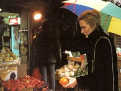 a woman holding an orange under an umbrella