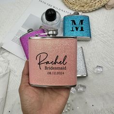 a person holding a pink and blue flask with the name rachel bridesmaid on it