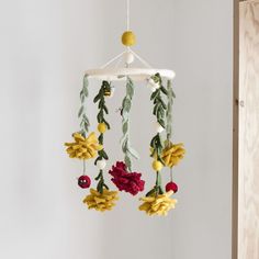 a crocheted mobile with flowers hanging from it's sides in a room