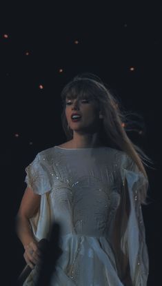 a woman in a white dress holding a microphone