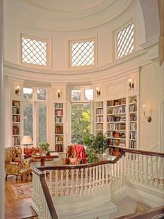 a staircase leading to the upper level of a home with bookshelves on either side