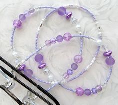 CJ's Inspirations "Sweet Lavender" This eyeglass lanyard makes a wonderful addition to your lanyard collection or a great gift for others. Features and Options: This eyeglass lanyard can also be converted to a mask lanyard so you never have to set your mask down when you're eating or need a break. The lanyard is connected using small jump rings and lobster clasps to make it easy to add eyeglass loops for a convertible piece of jewelry. To ensure durability and long-lasting wear, this lanyard has Purple Glass Beaded Necklaces With Round Beads, Purple Glass Beaded Necklace With Round Beads, Purple Glass Glasses Chains As Gift, Adjustable Purple Glass Beaded Necklaces, Adjustable Purple Glass Glasses Chains, Purple Glass Beaded Necklace, Glasses Chains, Mask Lanyard, Beaded Lanyards