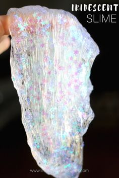 someone is holding up a large piece of white and pink holographic rock with the words, fluorescent descent slime on it