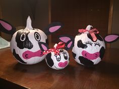 two decorated pumpkins with cows on them