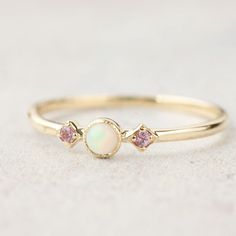 "Three stone opal and the pink sapphire ring is called \"Star and Moon Ring\", made in 100% recycled solid 14k gold featuring 3mm Australian white opal accented with pink sapphires on both sides. This unique ring is inspired by vintage art deco style ring, it is very lightweight and comfortable on your finger. Opal is known as the gem of brilliance and mystery. It is the birthstone for the month of October so it will make a unique birthday gift for October babies. Opal is a soft stone, please be Pink Sapphire Band, October Birthstone Jewelry, Leaf Engagement Ring, Zierlicher Ring, Pink Sapphire Ring, Engagement Ring White Gold, Moon Ring, Blue Sapphire Rings, October Birth Stone