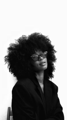 a woman with an afro sitting on a bench