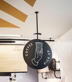 a coffee shop sign hanging from the ceiling