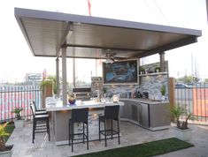 an outdoor kitchen and dining area on a patio