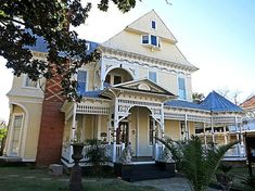 a large yellow house with blue roof and white trim