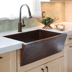 a kitchen sink sitting under a faucet next to a counter top with dishes on it