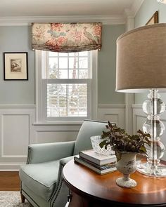 a living room filled with furniture and a lamp on top of a round wooden table