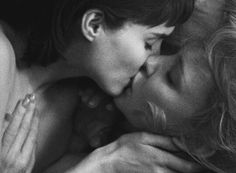 black and white photograph of two women kissing each other with their heads close to one another