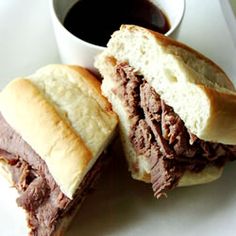 a roast beef sandwich cut in half with a cup of coffee