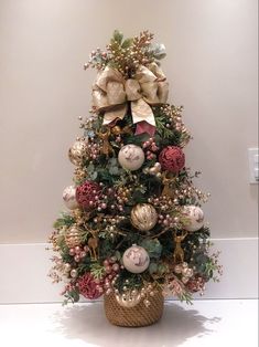 a small christmas tree with ornaments and bows