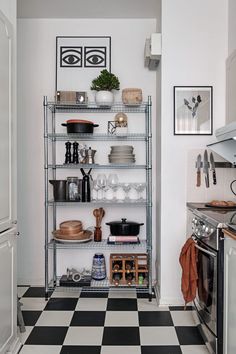 a kitchen with black and white checkered flooring, shelves filled with cooking utensils