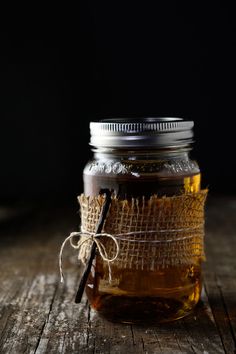 a jar filled with honey sitting on top of a wooden table