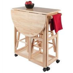 a wooden table with two chairs and a bowl of fruit on it's stand