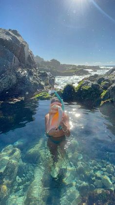 a woman is swimming in the clear blue water