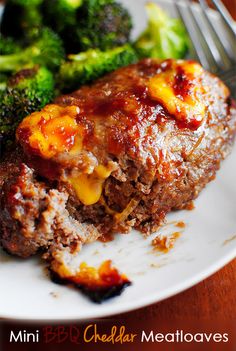 meatloaf and broccoli on a plate with a fork next to it