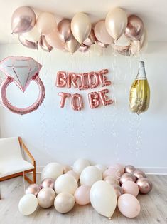 balloons and confetti are on the floor in front of a bride to be sign