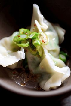 some dumplings are sitting in a bowl on the table