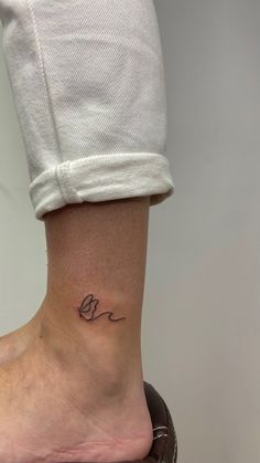 a woman's foot with a small tattoo on the side of her leg,