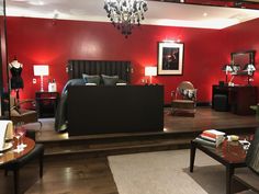 a bedroom with red walls and black furniture