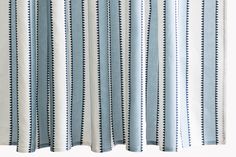 blue and white striped curtains hanging on the side of a window