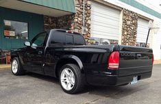 a black pickup truck parked in front of a building