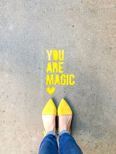 someone is standing in front of the words you are magic written on the ground with their feet