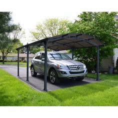 a car is parked in the driveway under a carport