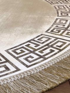 an area rug with fringes and designs on the floor in front of a wooden table