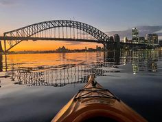 a kayak in the water with a bridge in the background